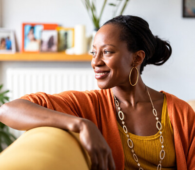 Woman smiling in a comfortable home setting, representing healing, emotional wellness, and personal growth through therapy in Ottawa and virtually across Ontario. 